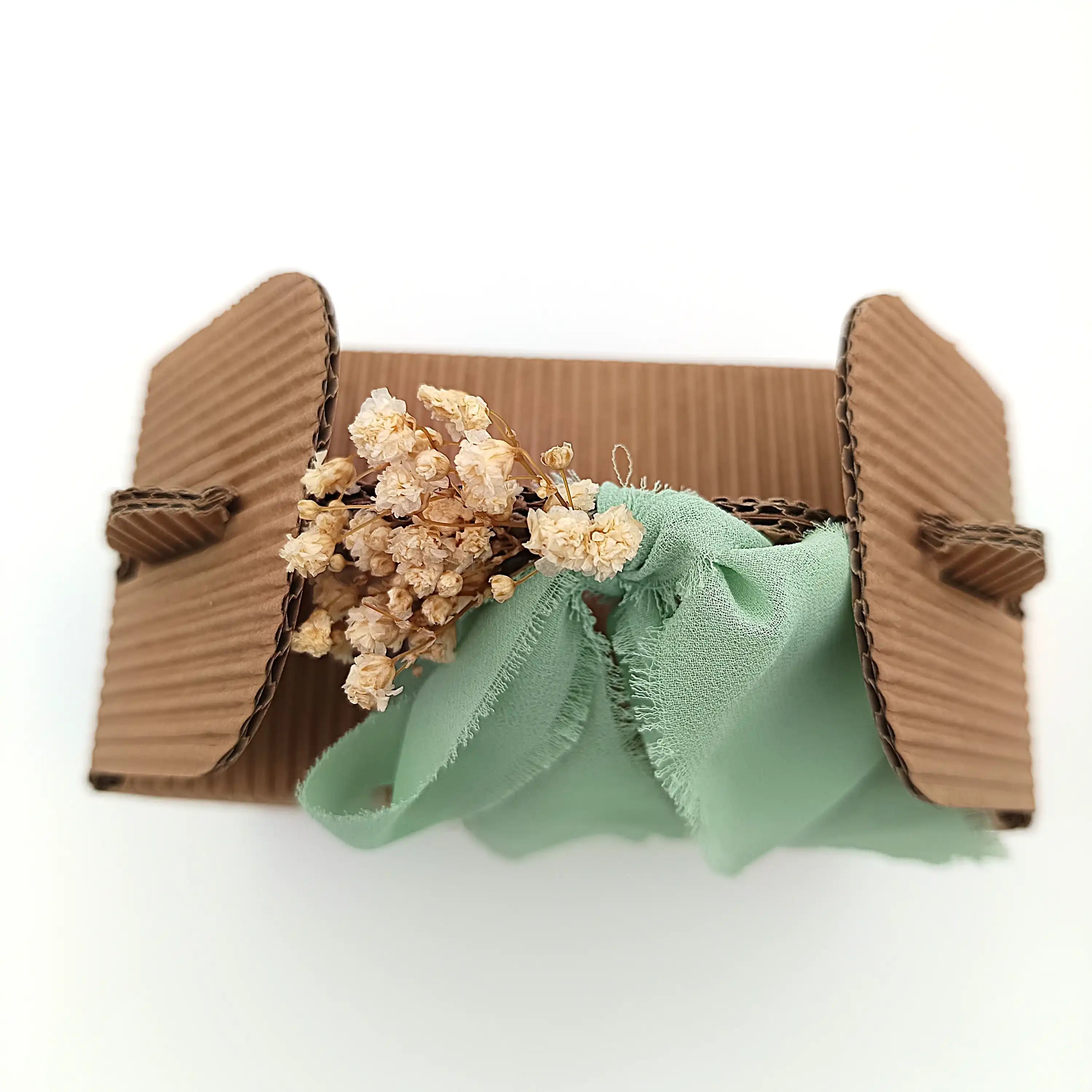 Handgefertigter Geschenkverpackung mit Trockenblumen und mintgrüner Schleife aus Stoff