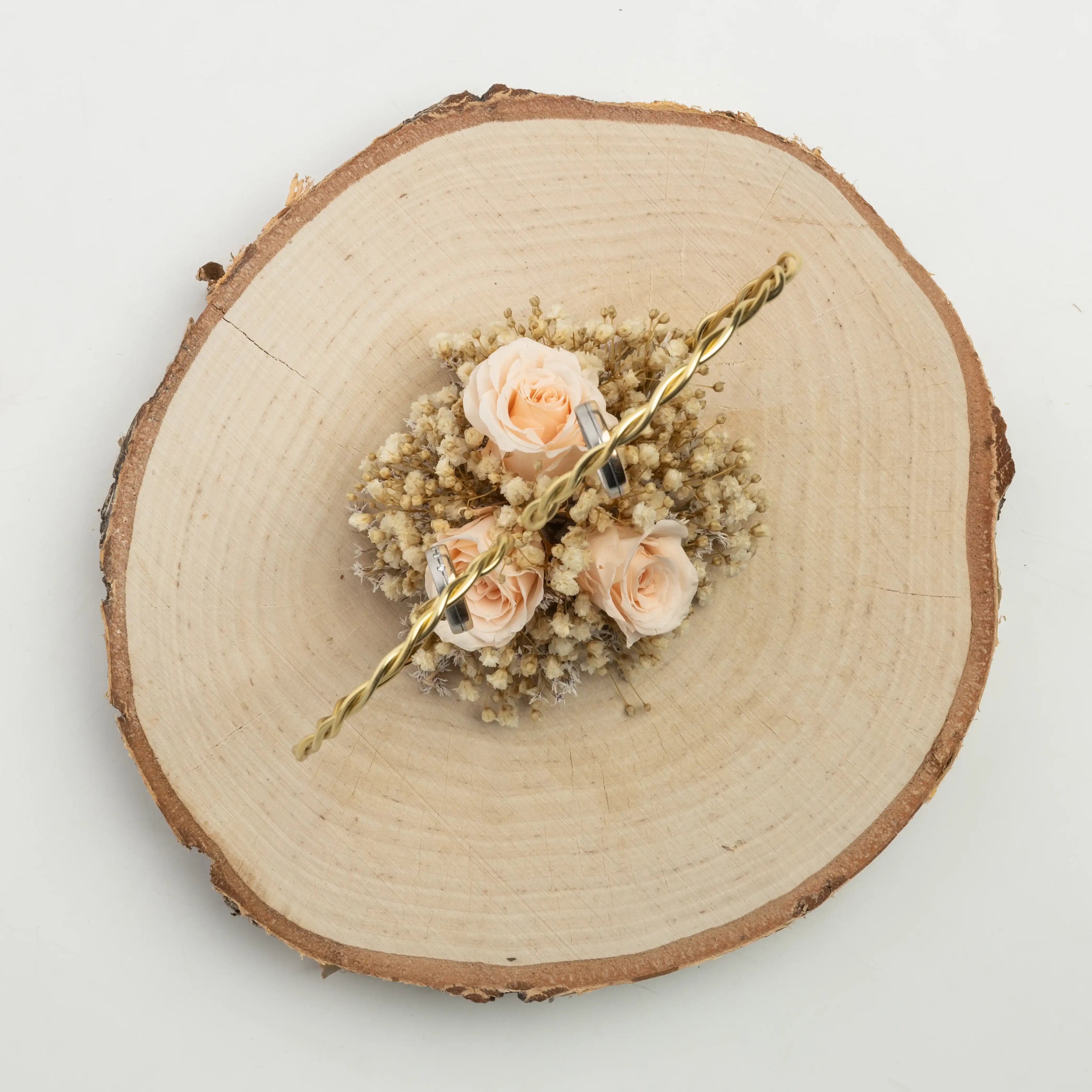 Handgefertigter Holzringhalter mit Trockenblumen und rosafarbenen Rosen